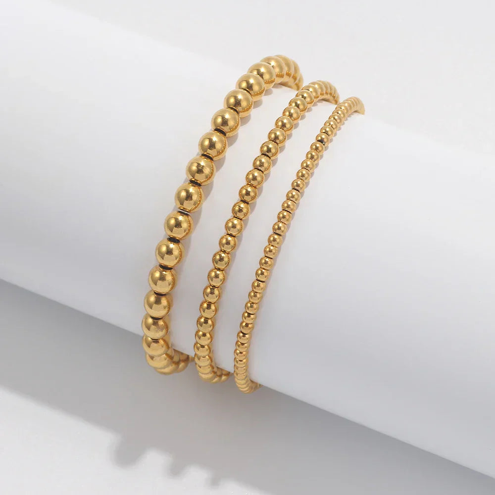 Set aus goldfarbenen Kugelarmbändern