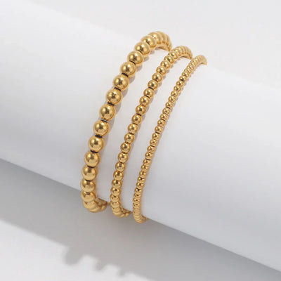 Set aus goldfarbenen Kugelarmbändern