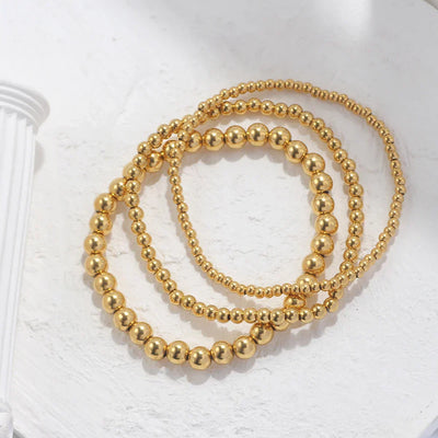 Set aus goldfarbenen Kugelarmbändern
